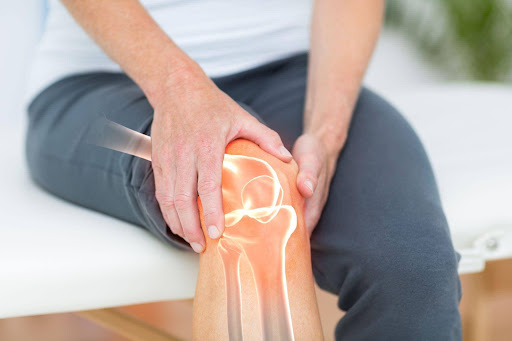 Person holding painful knee joint with highlighted knee pain and inflammation